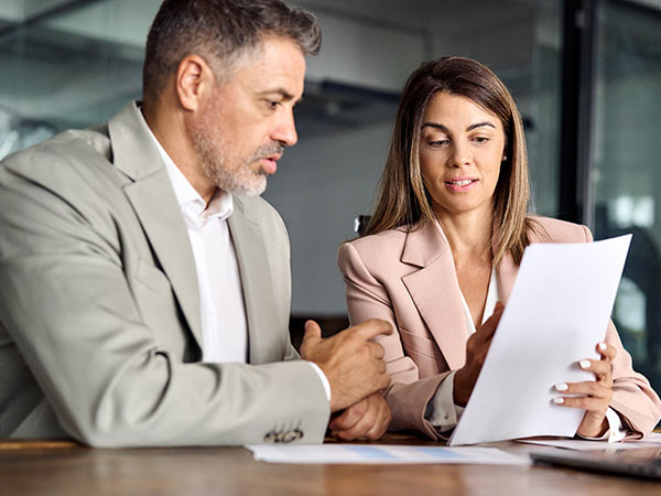 two people looking at documents in a meeting