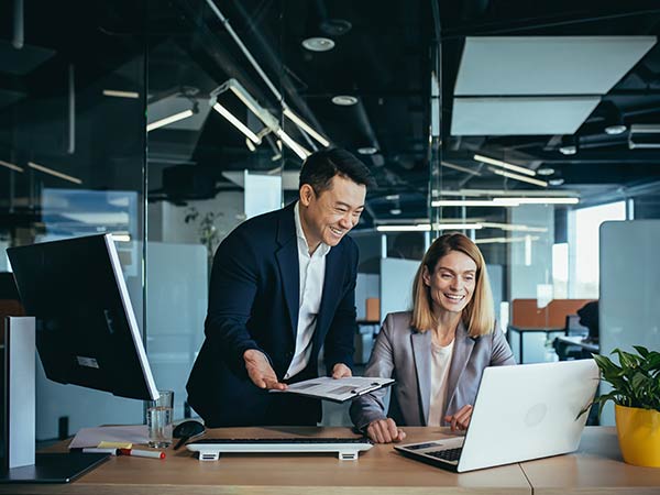 2 colleagues looking at laptop